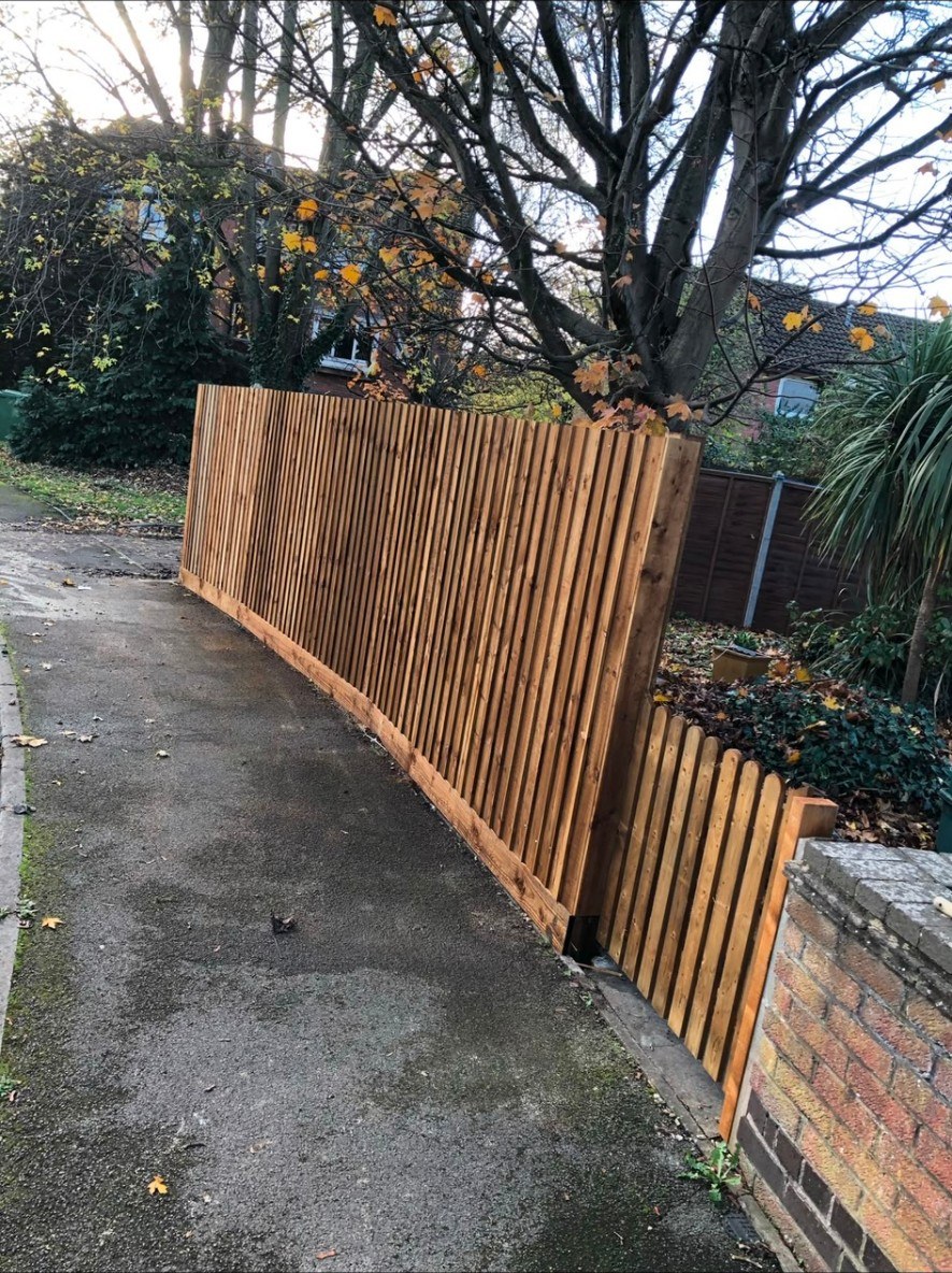 Vertical timber slat fencing and matching garden gate installed along a property boundary.