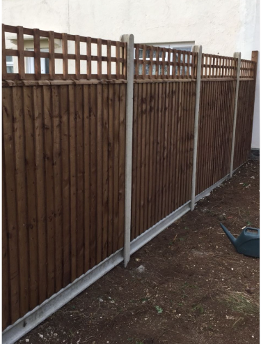 Closeboard timber fencing with trellis tops and concrete posts and gravel boards along a property boundary.
